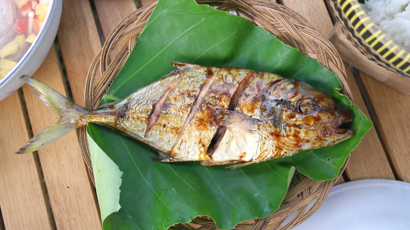 A whole grilled fish served on a banana leaf