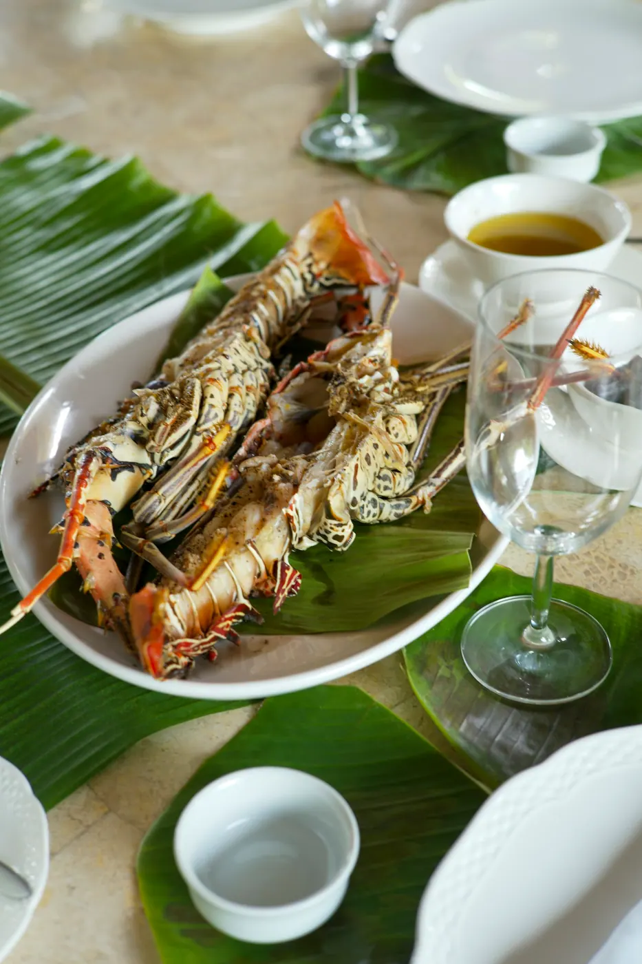 A plated seafood dish beside a glass on a restaurant table