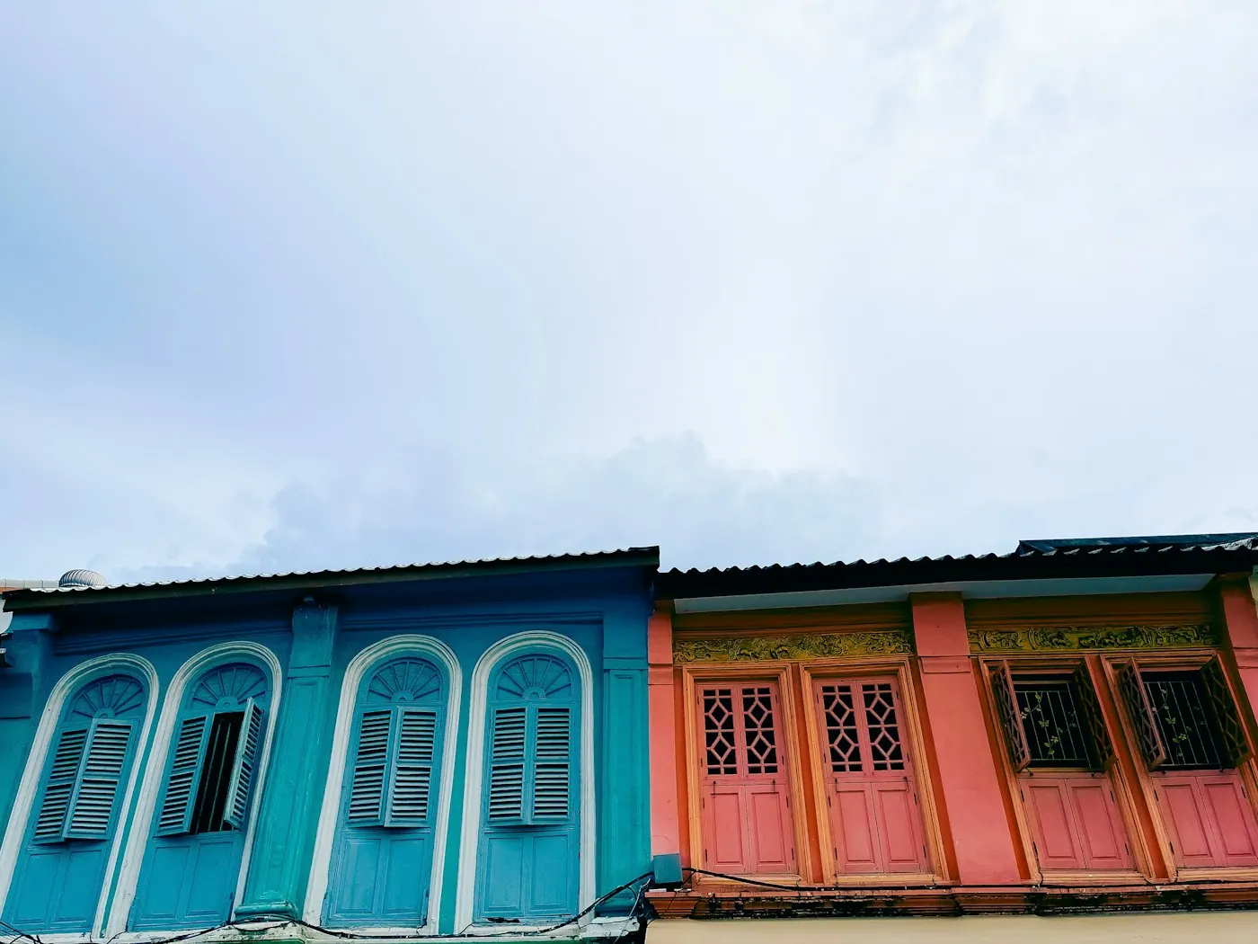 Brightly painted shophouse facades and louvred shutters