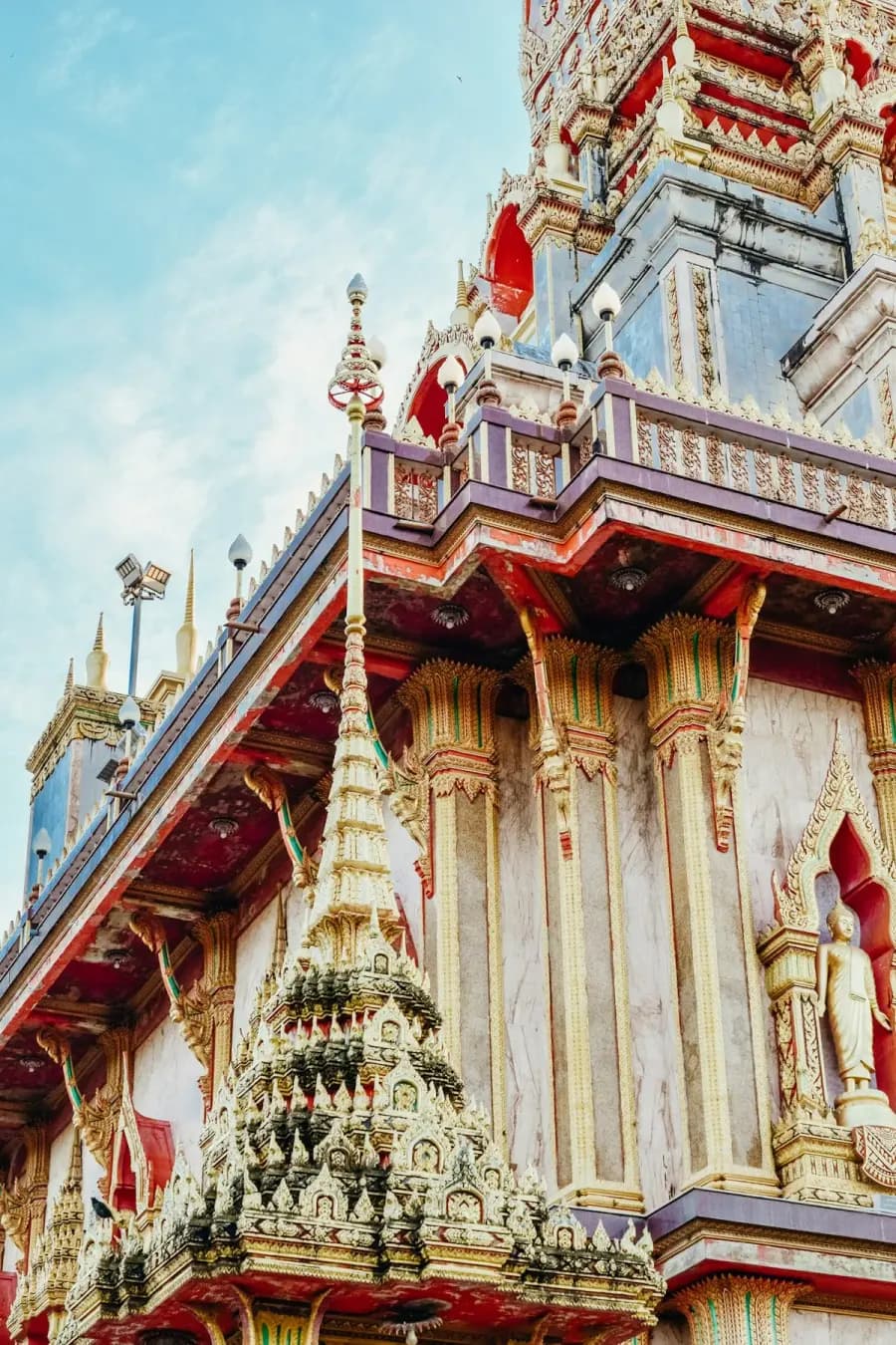 Red and gold architectural details at Wat Chalong in Phuket